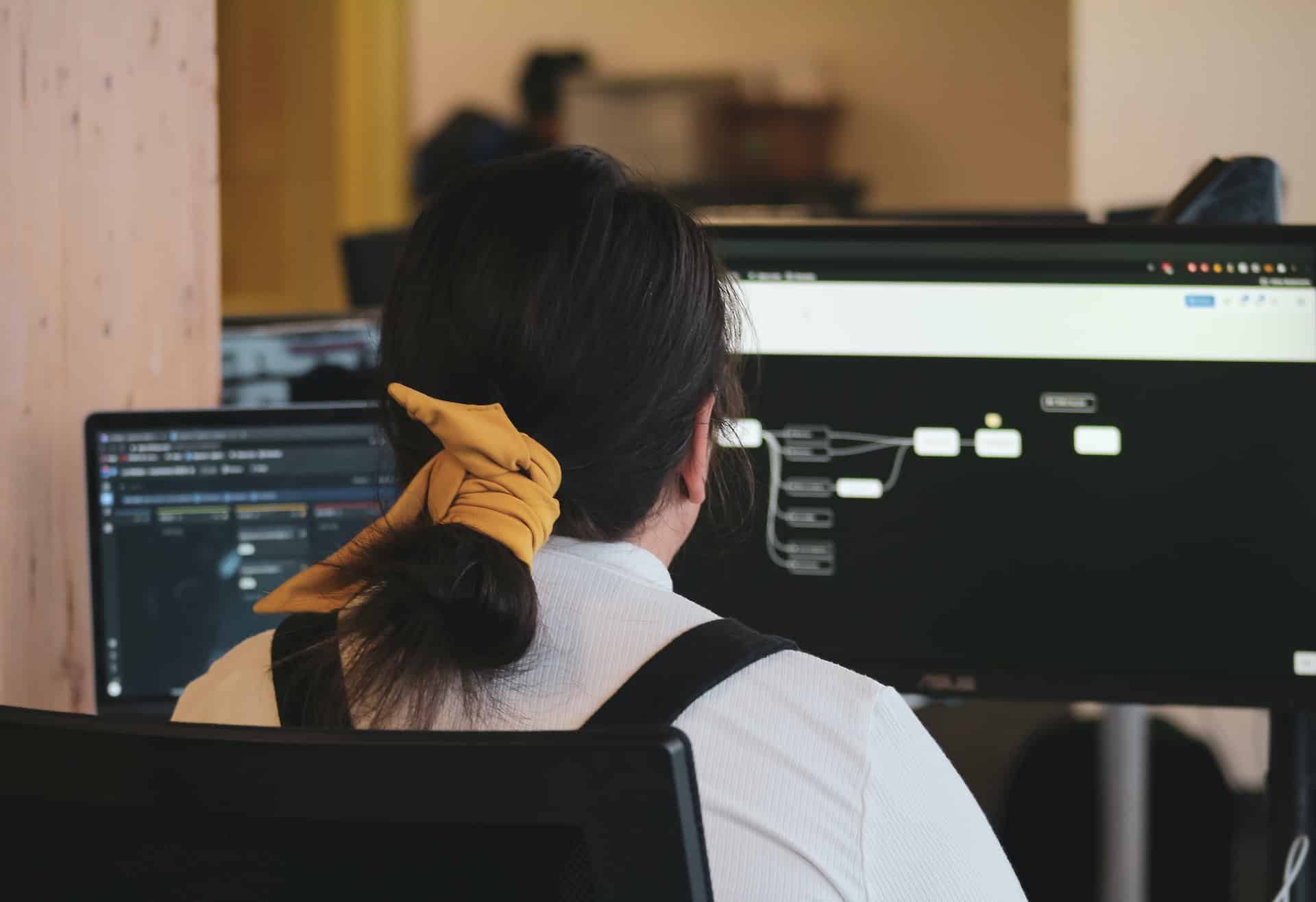 Das Bild einer Frau, die an einem Computer arbeitet, repräsentiert Skywize's Team von engagierten und qualifizierten Fachleuten im Bereich DevOps.